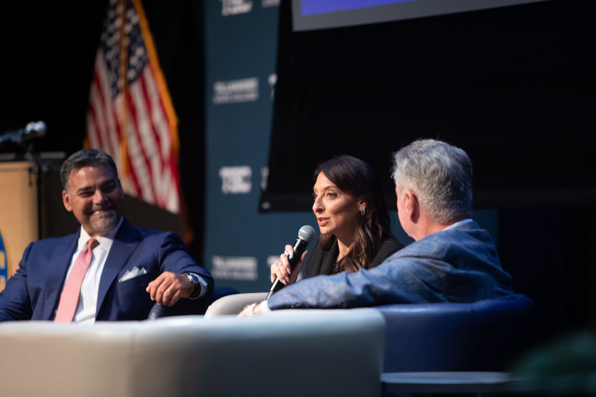 Summit panels speaking together on stage.