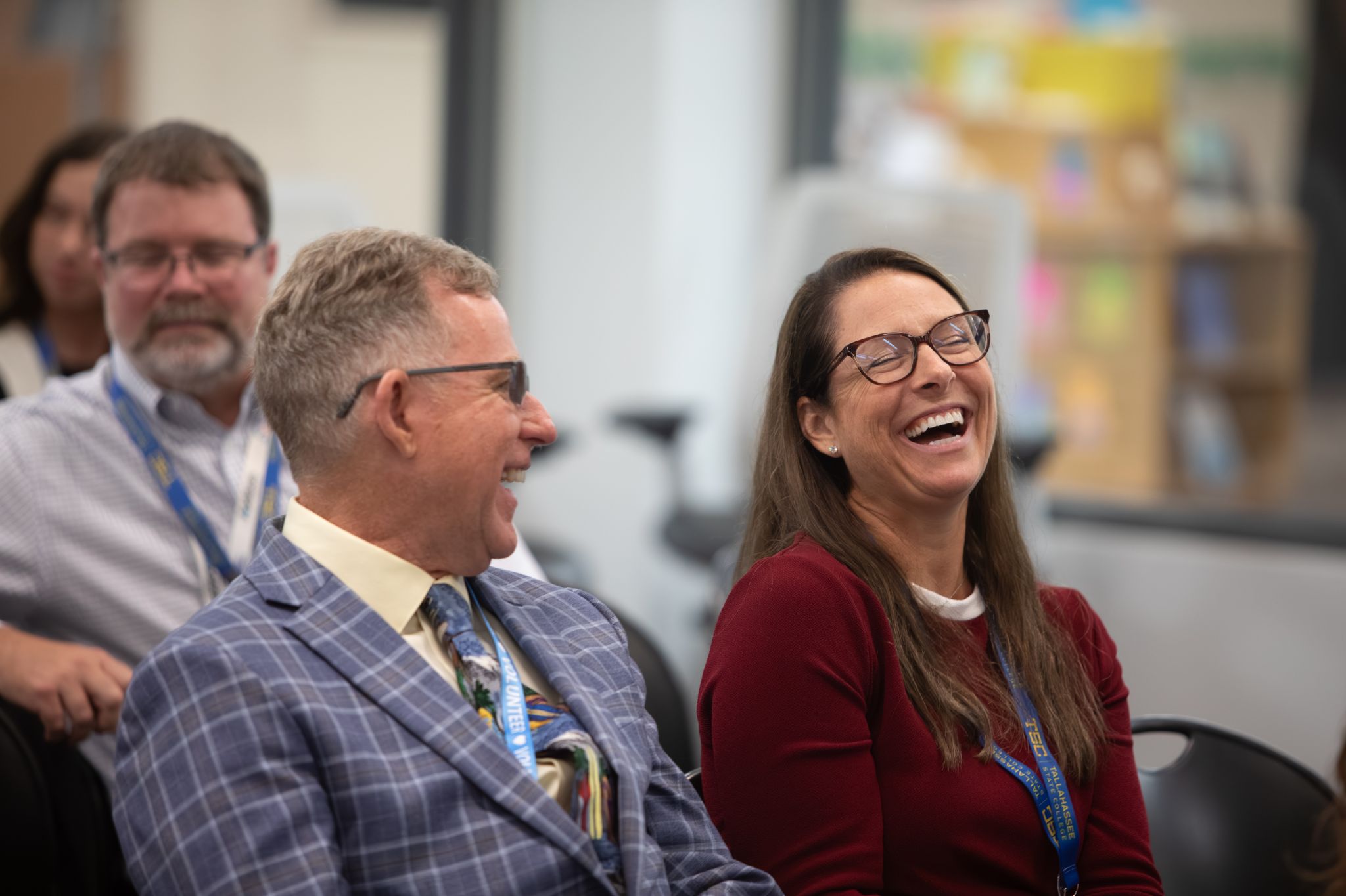 Attendees laughing together in session classroom.