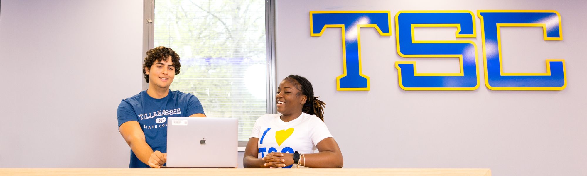 Two students looking at a laptop together.