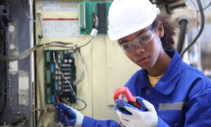 Female electrician checking an electrical box.