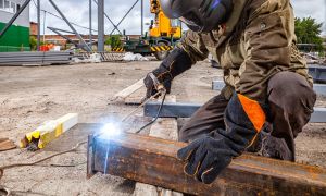 Welding working on construction site.